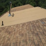 An asphalt shingle roof with missing shingles in need of repair.