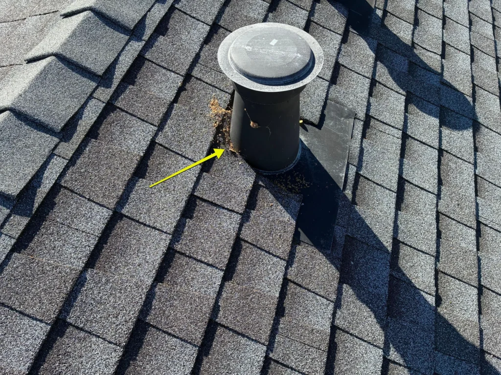 Roof valley intersection with metal flashing and debris buildup identified during a roof leak inspection.